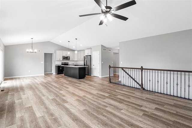 1448 Guilford Pl, Troy, IL 62294 - unfurnished living room with lofted ceiling, ceiling fan, a chandelier, baseboards, and light wood-type flooring