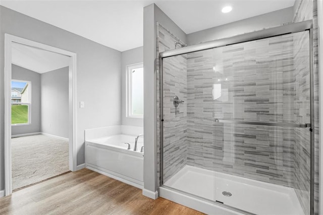 1448 Guilford Pl, Troy, IL 62294 - bathroom with a bath, a stall shower, wood finished floors, and baseboards