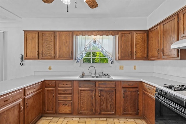 8800 Country Ln, Troy, IL 62294 - kitchen with a sink, ceiling fan, brown cabinetry, under cabinet range hood, and light countertops