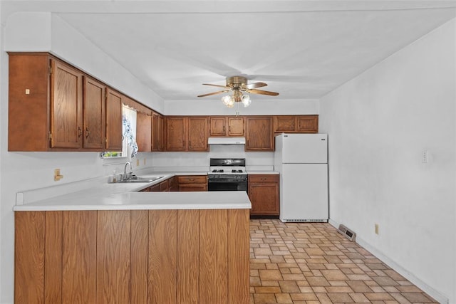 8800 Country Ln, Troy, IL 62294 - kitchen with freestanding refrigerator, a sink, gas stove, under cabinet range hood, and a peninsula