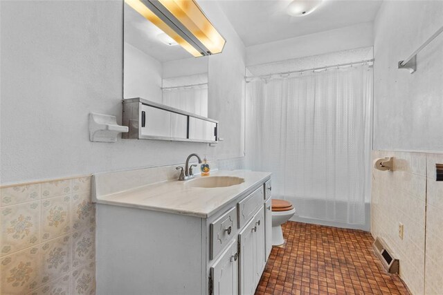 8800 Country Ln, Troy, IL 62294 - bathroom with tile walls, vanity, toilet, shower / bath combo with shower curtain, and a wainscoted wall