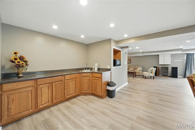 15900 Woodlet Way Ct, Chesterfield, MO 63017 - kitchen featuring a sink, light wood-type flooring, open floor plan, recessed lighting, and dark countertops