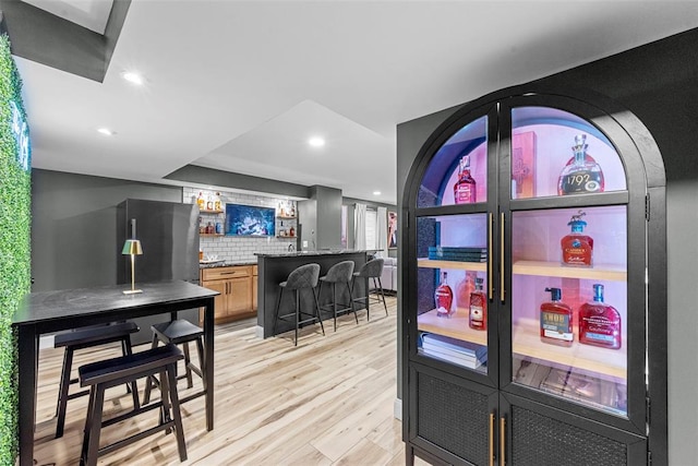 369 Tiber Pl, Saint Charles, MO 63301 - kitchen featuring refrigerator, a breakfast bar, backsplash, light wood finished floors, and recessed lighting