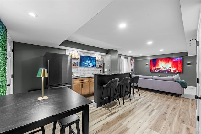 369 Tiber Pl, Saint Charles, MO 63301 - indoor wet bar featuring recessed lighting, light wood-style flooring, tasteful backsplash, and freestanding refrigerator