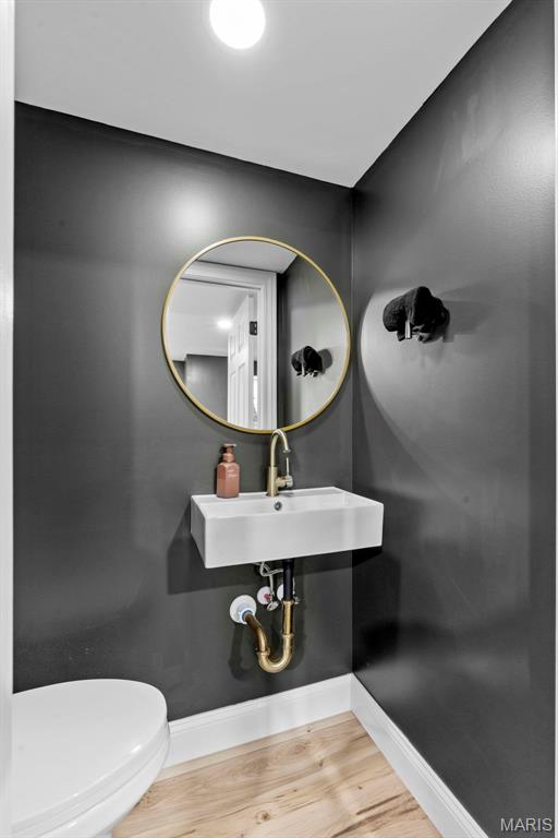 369 Tiber Pl, Saint Charles, MO 63301 - half bath featuring baseboards, a sink, wood finished floors, and toilet