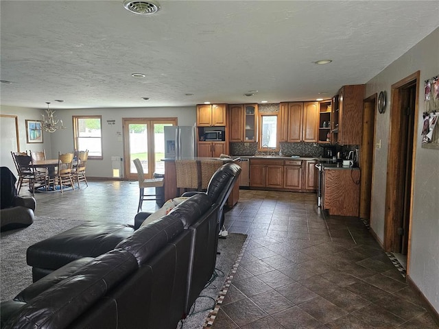 202 Jeremiah, Willisville, IL 62997 - living room featuring a chandelier, baseboards, a textured ceiling, recessed lighting, and stone tile flooring