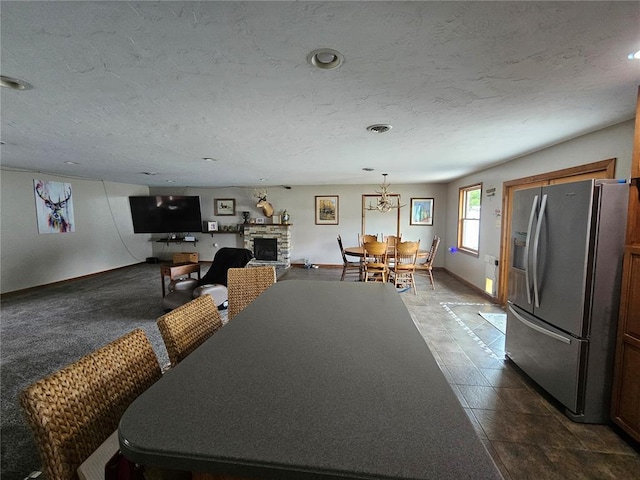 202 Jeremiah, Willisville, IL 62997 - dining area featuring baseboards, a textured ceiling, a stone fireplace, a chandelier, and recessed lighting
