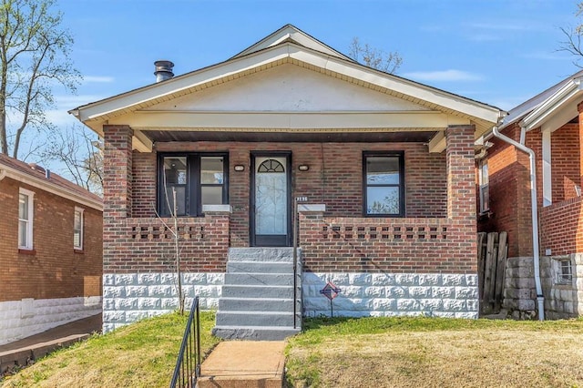 7116 Edison Ave, Velda City, MO 63121 - view of front facade with brick siding, a porch, and a front lawn