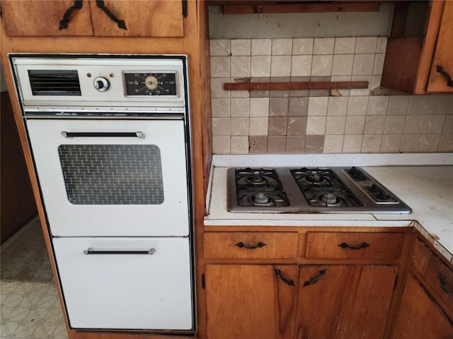 1505 Dale St, Van Buren, MO 63965 - kitchen with white oven, gas stovetop, light countertops, and brown cabinetry
