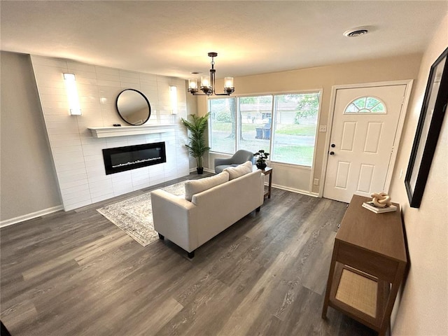 436 S 5th St, Caseyville, IL 62232 - living area featuring dark wood-type flooring, baseboards, a fireplace, and a chandelier