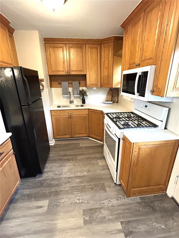 436 S 5th St, Caseyville, IL 62232 - kitchen featuring white appliances, a sink, wood finished floors, and brown cabinets