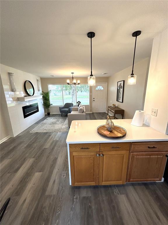 436 S 5th St, Caseyville, IL 62232 - kitchen with dark wood-style flooring, a glass covered fireplace, a peninsula, open floor plan, and light countertops