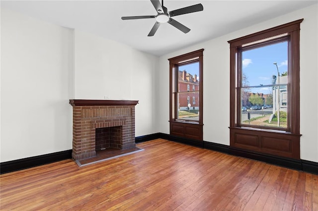 2856 Wyoming St, Saint Louis, MO 63118 - unfurnished living room with hardwood / wood-style floors, a ceiling fan, a fireplace, and baseboards