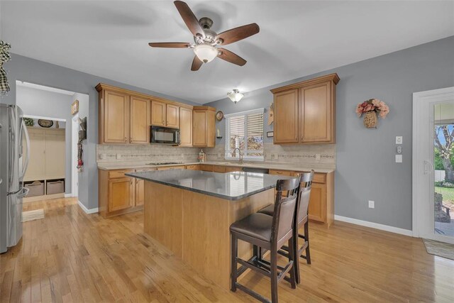 1002 Brook Mont Dr, Ofallon, MO 63366 - kitchen with black microwave, freestanding refrigerator, backsplash, and a kitchen bar