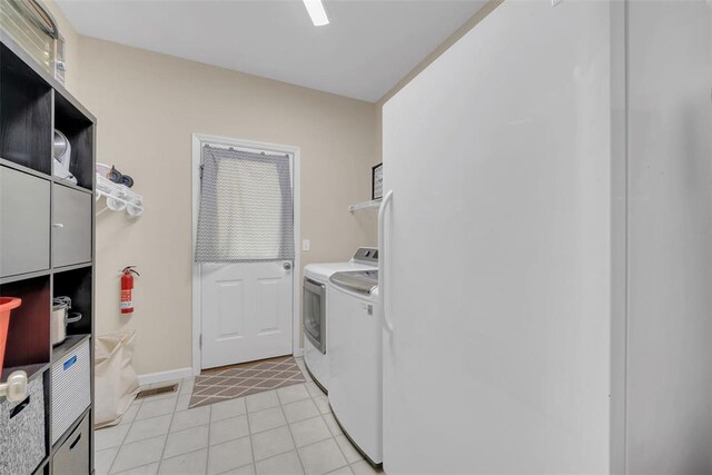 1002 Brook Mont Dr, Ofallon, MO 63366 - washroom with separate washer and dryer, light tile patterned floors, and baseboards