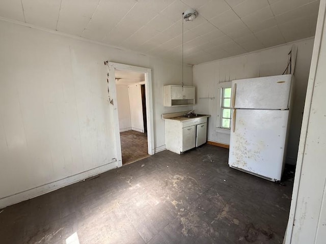 504 E 8th St, Portageville, MO 63873 - kitchen with freestanding refrigerator, a sink, white cabinetry, and light countertops