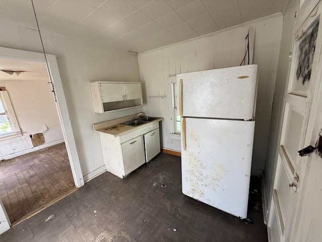 504 E 8th St, Portageville, MO 63873 - kitchen featuring freestanding refrigerator, a sink, light countertops, and white cabinetry