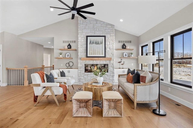 973 Buckner Rd, Wentzville, MO 63385 - living room with ceiling fan, high vaulted ceiling, light wood finished floors, a stone fireplace, and baseboards