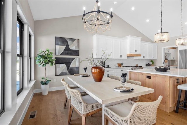 973 Buckner Rd, Wentzville, MO 63385 - kitchen featuring a chandelier, a center island with sink, tasteful backsplash, healthy amount of natural light, and high vaulted ceiling