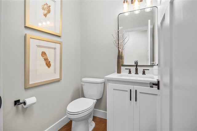973 Buckner Rd, Wentzville, MO 63385 - half bathroom with toilet, vanity, baseboards, and wood finished floors