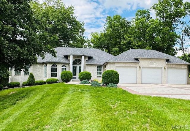 2700 Hyacinth Ave, Hannibal, MO 63401 - view of front facade with an attached garage, a front lawn, concrete driveway, french doors, and a shingled roof