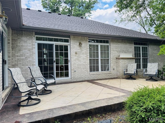2700 Hyacinth Ave, Hannibal, MO 63401 - back of house featuring roof with shingles, brick siding, and a patio area