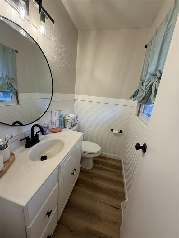 1517 Morning Glory Dr, Vandalia, IL 62471 - half bathroom with wood finished floors, toilet, wainscoting, vanity, and a textured wall