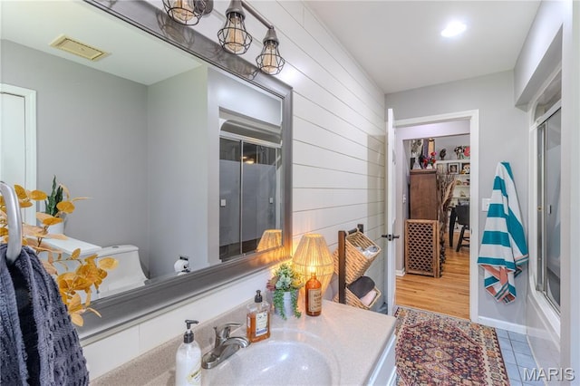 700 Lariat Ln, Rolla, MO 65401 - bathroom featuring a shower with door, vanity, and wooden walls