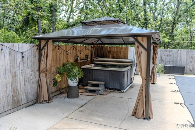 700 Lariat Ln, Rolla, MO 65401 - fenced backyard featuring a gazebo, a hot tub, a patio area, and view of wooded area
