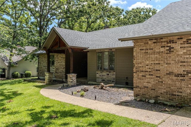 700 Lariat Ln, Rolla, MO 65401 - entrance to property featuring a lawn, a shingled roof, and brick siding