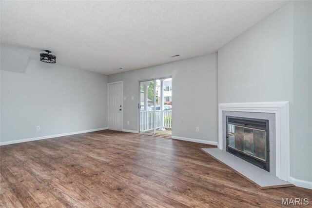 1447 Oriole Pl, Brentwood, MO 63144 - unfurnished living room with a fireplace, wood finished floors, baseboards, and a textured ceiling