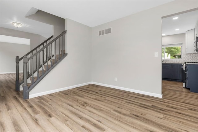 904 Hunter Ln, Lake St Louis, MO 63367 - unfurnished living room with light wood-type flooring, baseboards, stairway, and recessed lighting
