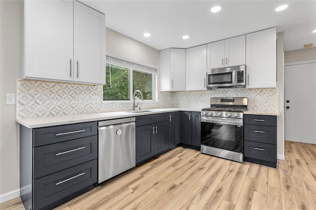 904 Hunter Ln, Lake St Louis, MO 63367 - kitchen featuring stainless steel appliances, a sink, white cabinetry, light wood-style floors, and recessed lighting