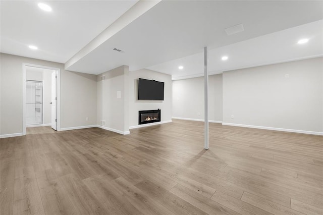 904 Hunter Ln, Lake St Louis, MO 63367 - unfurnished living room featuring a glass covered fireplace, baseboards, light wood finished floors, and recessed lighting