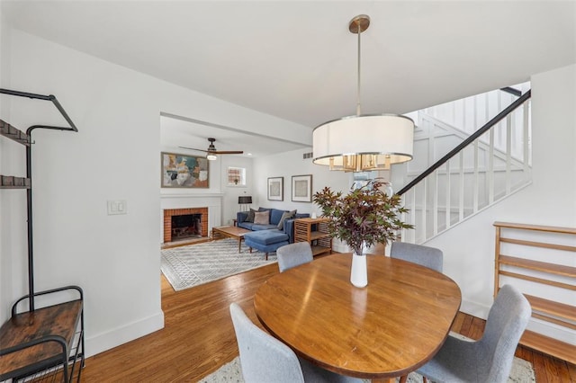 6708 Etzel Ave, University City, MO 63130 - dining space with wood finished floors, a ceiling fan, stairs, baseboards, and a fireplace