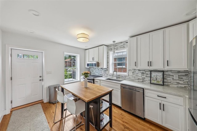 6708 Etzel Ave, University City, MO 63130 - kitchen featuring stainless steel appliances, plenty of natural light, tasteful backsplash, and light countertops