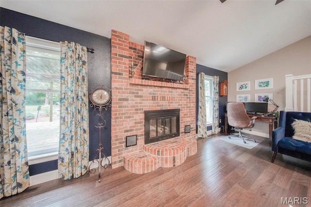 1708 Line Ave, Rolla, MO 65401 - living room with wood finished floors, vaulted ceiling, a fireplace, an office area, and healthy amount of natural light
