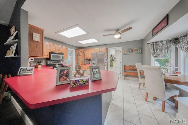 1708 Line Ave, Rolla, MO 65401 - kitchen with appliances with stainless steel finishes, light marble finish flooring, a peninsula, ceiling fan, and light brown cabinets