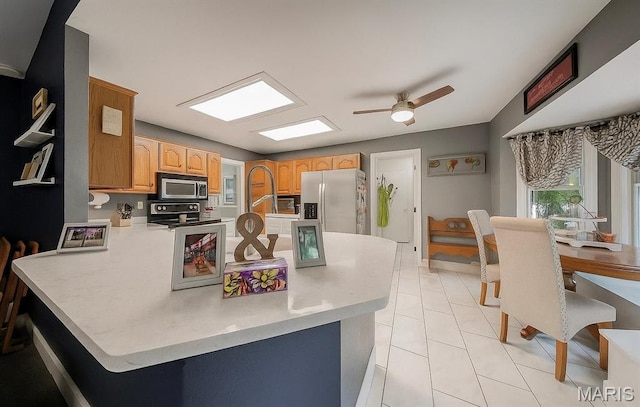 1708 Line Ave, Rolla, MO 65401 - kitchen with stainless steel appliances, a peninsula, a ceiling fan, and light countertops