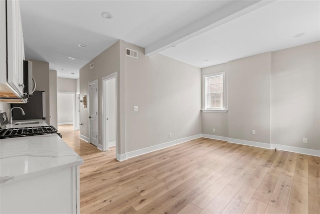 3535 Giles Ave, Saint Louis, MO 63116 - kitchen with baseboards, light stone counters, light wood-type flooring, white cabinets, and recessed lighting