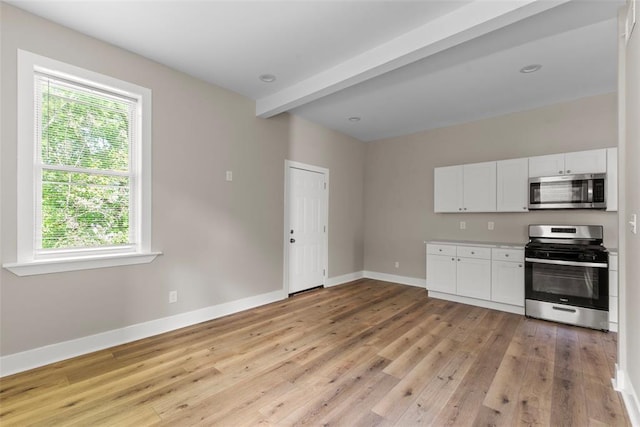 3535 Giles Ave, Saint Louis, MO 63116 - kitchen with stainless steel appliances, healthy amount of natural light, baseboards, white cabinetry, and beamed ceiling