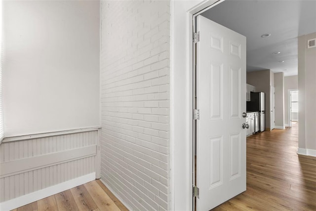 3535 Giles Ave, Saint Louis, MO 63116 - corridor with light wood-style floors, brick wall, and baseboards