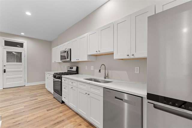 3535 Giles Ave, Saint Louis, MO 63116 - kitchen with appliances with stainless steel finishes, a sink, light countertops, light wood-type flooring, and recessed lighting