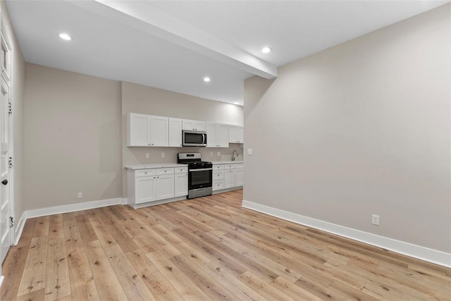 3535 Giles Ave, Saint Louis, MO 63116 - kitchen featuring appliances with stainless steel finishes, baseboards, white cabinets, light countertops, and a sink