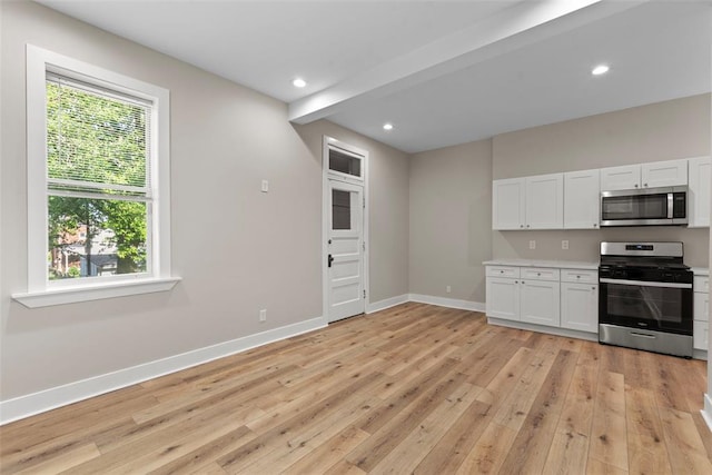 3535 Giles Ave, Saint Louis, MO 63116 - kitchen with appliances with stainless steel finishes, light wood-style flooring, baseboards, white cabinetry, and light countertops