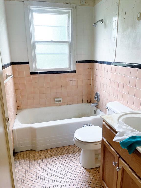 708 E State Route 72, Rolla, MO 65401 - full bath featuring toilet, tile walls, vanity, tile patterned floors, and washtub / shower combination