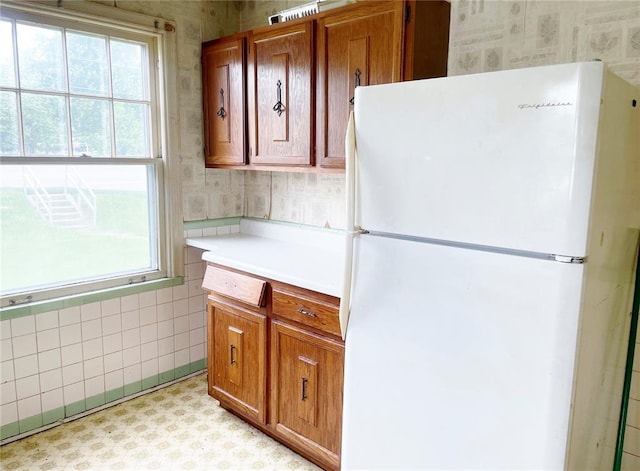 708 E State Route 72, Rolla, MO 65401 - kitchen featuring freestanding refrigerator, wallpapered walls, plenty of natural light, light countertops, and brown cabinetry