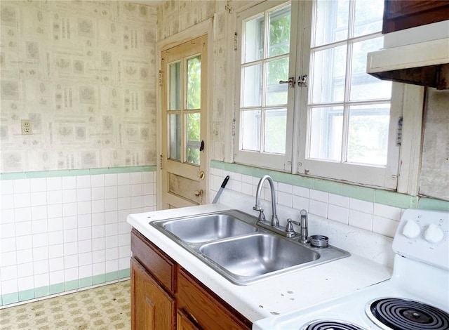 708 E State Route 72, Rolla, MO 65401 - kitchen featuring wallpapered walls, range, a sink, light countertops, and tile walls