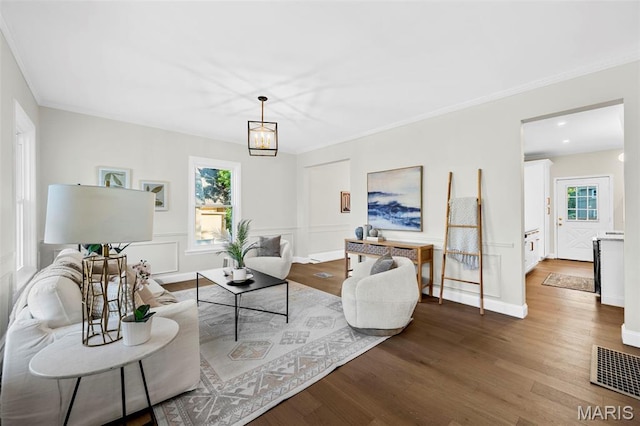 317 Greeley Ave, Webster Groves, MO 63119 - living area featuring wood finished floors, plenty of natural light, ornamental molding, and a chandelier