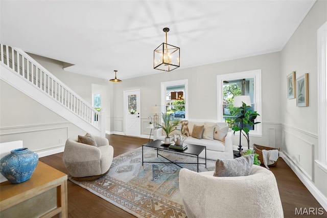 317 Greeley Ave, Webster Groves, MO 63119 - living area with stairs, dark wood-style floors, a chandelier, a decorative wall, and a wainscoted wall